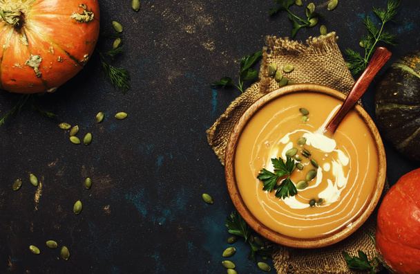 Cream pumpkin soup in a wooden bowl, rustic style, top view - 写真・画像
