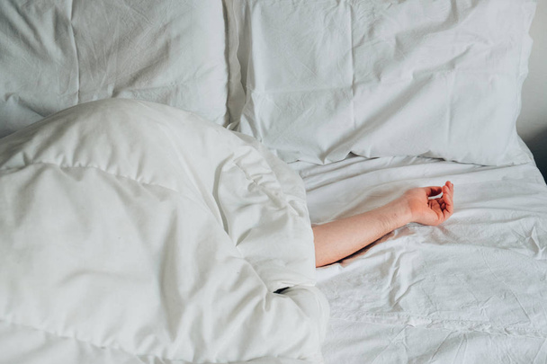 Ленивый человек прячется на белой кровати
 - Фото, изображение