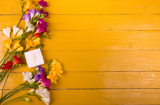 木製の背景にフリージアの花の花束 - 写真・画像