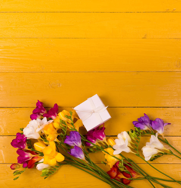 Bouquet of freesia flowers on a wooden background - Photo, Image