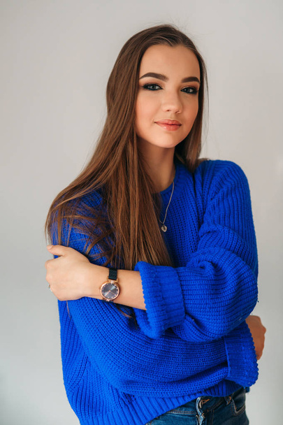 Piękna brunetka dziewczyna z pięknym uśmiechem w niebieska bluzka pozowanie dla fotografa i pokazano jej makijaż - Zdjęcie, obraz