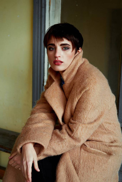 Beautiful young woman in fashionable coat posing  - Фото, изображение