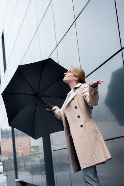 businesswoman in stylish coat with umbrella on street - Zdjęcie, obraz