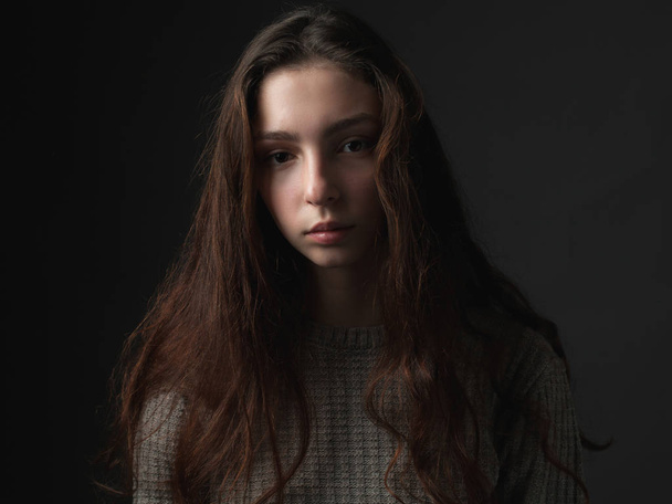 Portrait of young woman on dark background - Foto, afbeelding