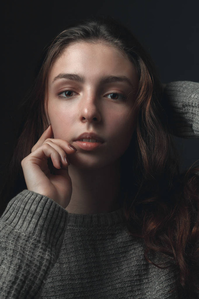 Portrait of young woman with hand touching face - Foto, Imagen