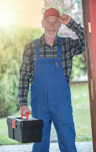 Portrait of a repairman holding his toolbox, light effect - Fotó, kép