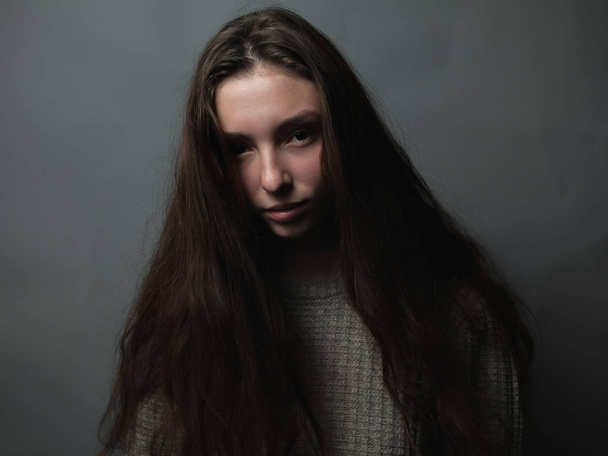 Portrait of young woman on grey background - Fotoğraf, Görsel