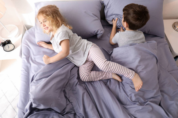 Cute little children trying to fall asleep in bed at home. Family bedtime - Photo, image