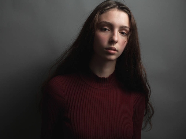 Portrait of young woman on grey background - Zdjęcie, obraz