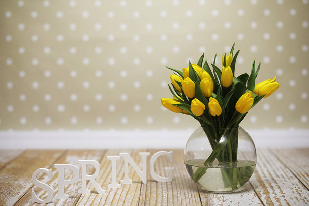 ein Strauß gelber Tulpen in einer Vase auf dem Boden. ein Geschenk an ein w - Foto, Bild