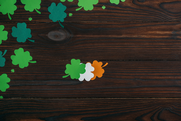 top view of clovers in colors of irish flag on wooden table - Фото, зображення