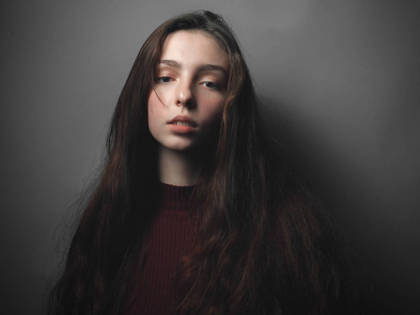 Portrait of young woman on grey background - Valokuva, kuva