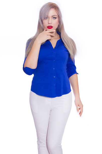 Studio business portrait of a young blonde woman in a dark blue shirt and white trousers. Girl posing on isolated white background. Smiling, looking at the camera - Fotó, kép