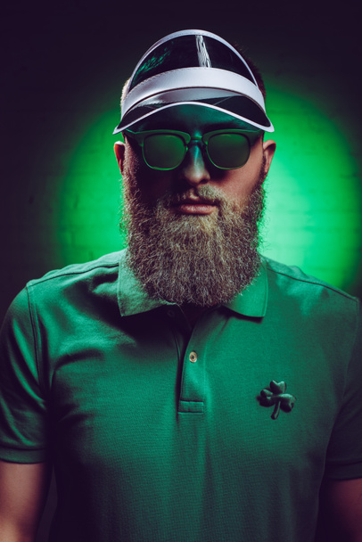 szép szakállas ember a shamrock szimbólum zöld póló  - Fotó, kép
