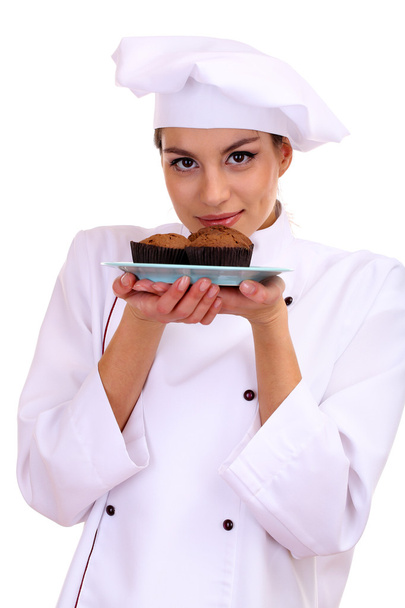 Portrait of young woman chef with cake on plate isolated on white - Foto, Imagen