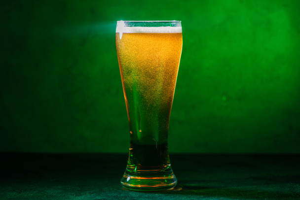 vista ravvicinata di vetro con birra ambrata fredda fresca su verde
 - Foto, immagini