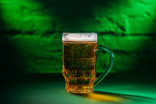 γκρο πλαν θέα παγωμένη μπύρα σε ποτήρι στο πράσινο φως - Φωτογραφία, εικόνα