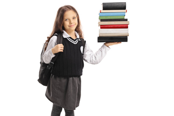 Little schoolgirl holding a stack of books isolated on white background - Foto, Bild