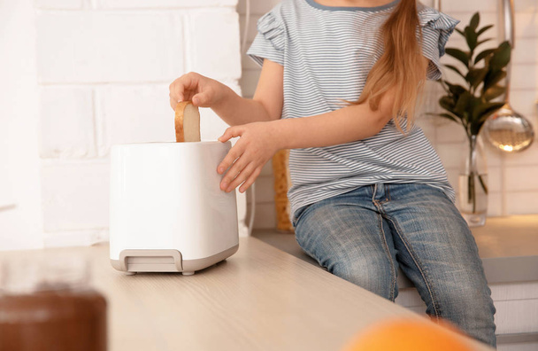 Little girl toasting bread at home - Foto, immagini