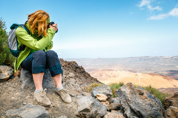 Młoda kobieta podziwia piękne widoki na góry i robi zdjęcia - Zdjęcie, obraz