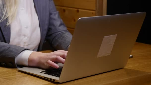 Mujer joven que trabaja en el ordenador portátil moderno en la cafetería
 - Metraje, vídeo
