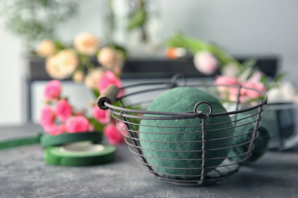 Metal basket with floral sponge on table - Φωτογραφία, εικόνα