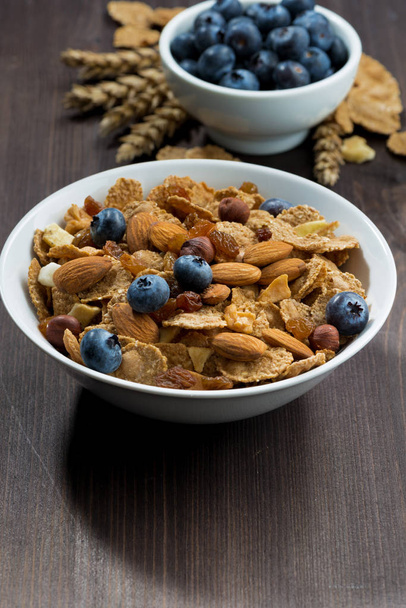 cereal flakes with blueberries and nuts on wooden table - Foto, imagen