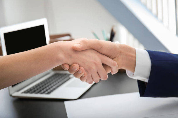 Lawyer shaking hands with client in office, closeup - Foto, imagen