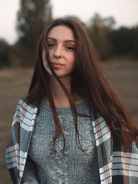 portrait of young woman with plaid on shoulders standing on field  - Foto, Imagem