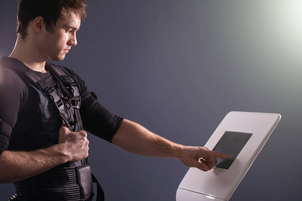 athlete regulating intensity of ems electro muscular stimulation machine - Foto, Imagem