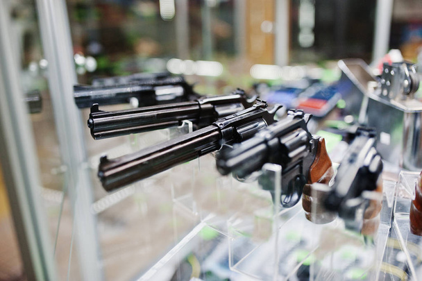 Different guns and revolvers on shelves store weapons on shop ce - Foto, afbeelding