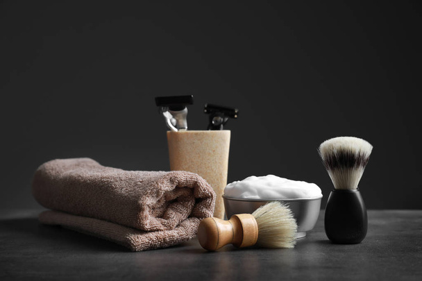 Shaving accessories for man on table against dark background - Foto, afbeelding