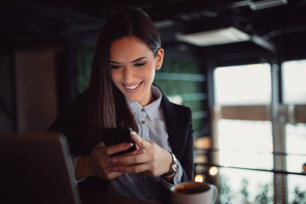 junge Geschäftsfrau nutzt Handy in der Mittagspause - Foto, Bild
