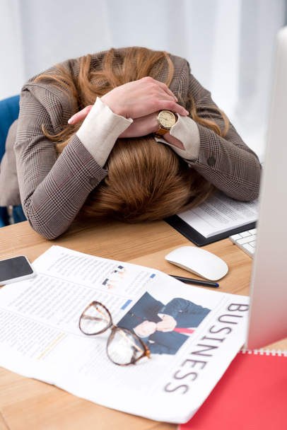 gedeeltelijke weergave van uitgeput zakenvrouw slapen op werkplek met documenten in office - Foto, afbeelding