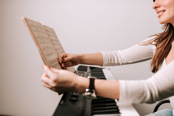 Close-up image of female pianist holding sheet music. Preparing before playing. - Foto, imagen