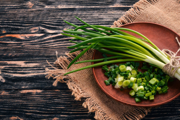 Fresh green onion on a wooden background. Top view. Free space for your text. - Foto, Imagem