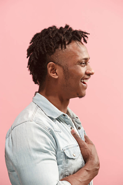 The happy business Afro-American man standing and smiling against pink background. Profile view. - Φωτογραφία, εικόνα