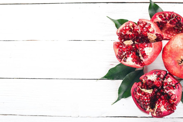 Pomegranate. On a white wooden background. Top view. Copy space. - 写真・画像