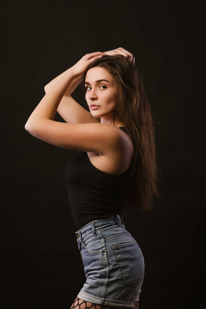 Model test with sexy young model in black shirt and jeans shorts - Zdjęcie, obraz