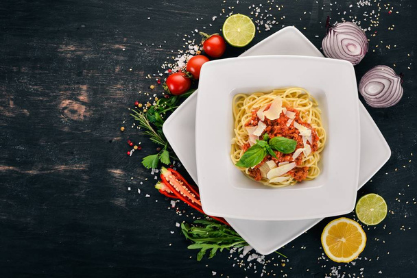 Italian cuisine. pasta with tomatoes and parmesan cheese. On a wooden background. Top view. Copy space. - Fotoğraf, Görsel