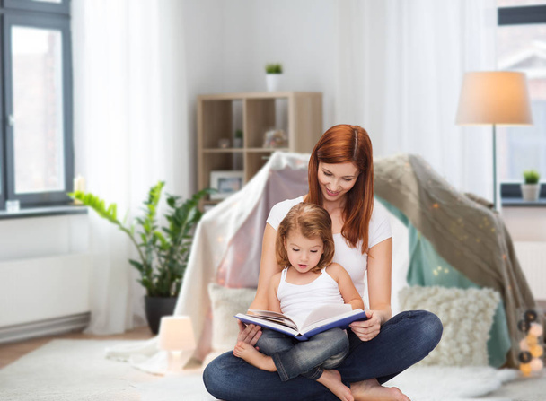 happy mother with little daughter reading book - Foto, Imagen