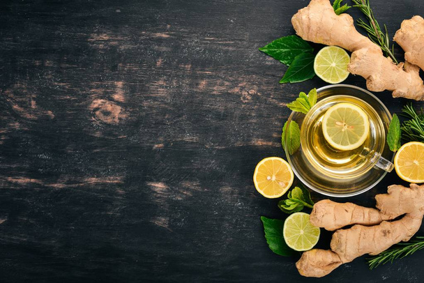 Tea with mint, ginger and lemon. Hot drink On a wooden background. Top view. Copy space. - Foto, imagen