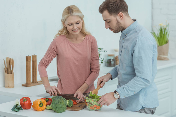 portrait of family cooking salad for dinner together at home - Zdjęcie, obraz