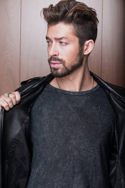 man fashion in leather jacket, wooden background - Photo, image