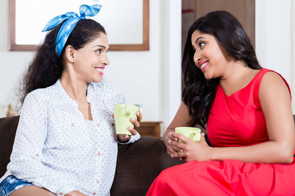 zwei Freundinnen, die drinnen Tee oder Kaffee trinken - Foto, Bild