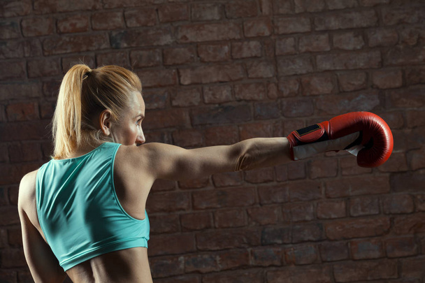 sports woman in boxing gloves is beating - Foto, immagini