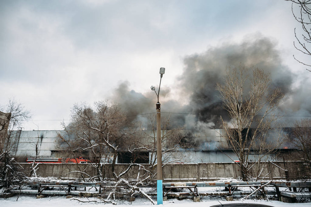 Incendio en un almacén industrial o fábrica, mucho humo y llamas
 - Foto, Imagen