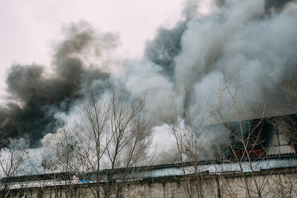 Incendio en un almacén industrial o fábrica, mucho humo y llamas
 - Foto, Imagen