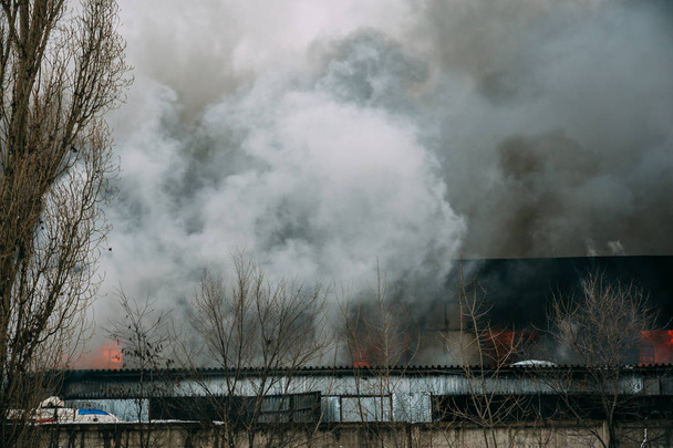 Brand in een industriële magazijn of fabriek, veel rook en vlammen - Foto, afbeelding