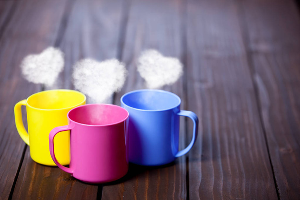 Три чашки чаю або кави з формою серця пари на дерев'яному фоні
  - Фото, зображення